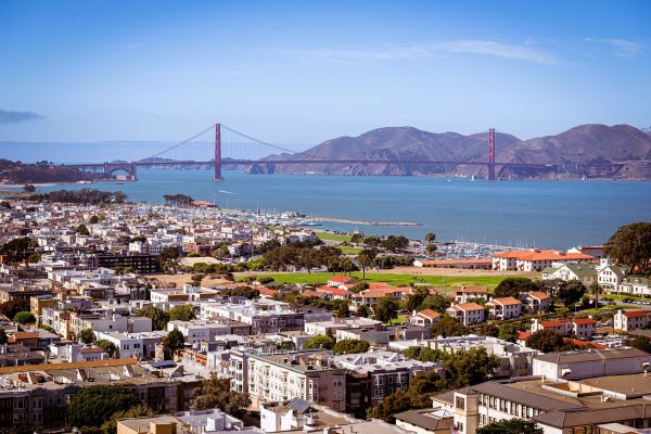 Aerial view of San Francisco with the Golden Gate Bridge and hills in the background on a clear day.