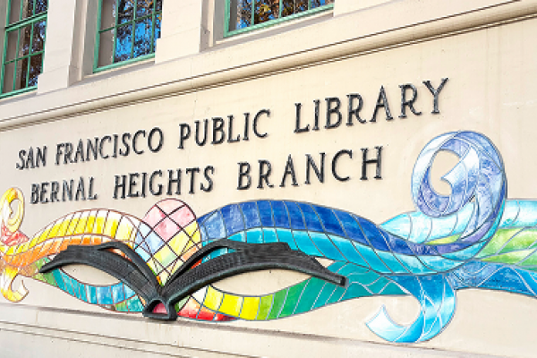 San Francisco Public Library Bernal Heights Branch sign with colorful book-themed mural on the building wall.