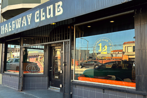 The exterior of The Halfway Club, with large windows and its name in bold letters above the entrance.